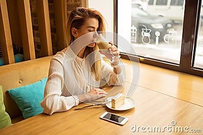 Young beautiful woman drinking latte in coffeeshop Stock Photo