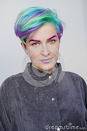 Young beautiful woman with dyed blue and green hair. Pixie bob short haircut The concept of hair styling. Stock Photo