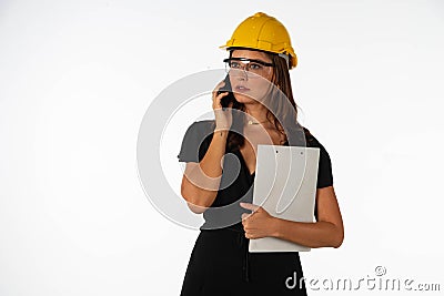 Young beautiful woman engineer holding mobile phone and folder on isolated white background Stock Photo