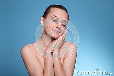 Young beautiful woman face portrait with healthy skin on blue background Stock Photo