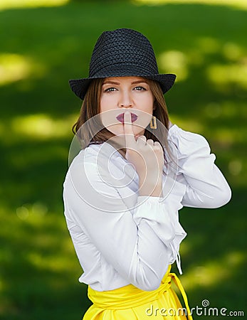 Young beautiful woman in hat shows hush sign Stock Photo