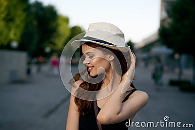 Young beautiful woman in a hat walking along a street in the city Stock Photo
