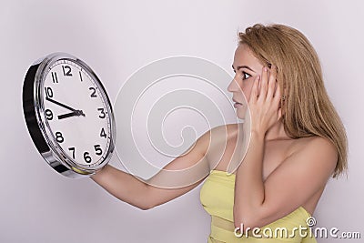 Young beautiful woman holding big clock. time concept. Stock Photo