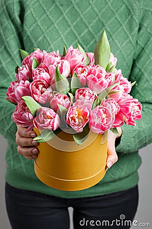 Young beautiful woman holding a bouquet of tulips in a gift box. pink colors in one box or bouquet. Present on March 8 Stock Photo