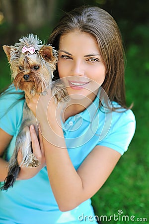 Young beautiful woman holding her puppy dog - outdoor portrait Stock Photo