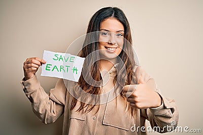 Young beautiful woman holding paper asking for save earth and enviroment conservation happy with big smile doing ok sign, thumb up Stock Photo