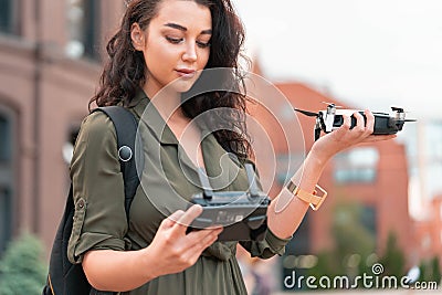 Young beautiful woman launching drone quadcopter at urban background. cityscape. modern device Stock Photo