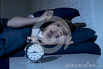 Young beautiful woman lying in bed late at night suffering from insomnia trying to sleep Stock Photo