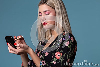 Young beautiful woman making make up with face powder Stock Photo