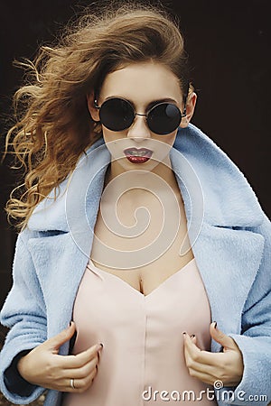 Young beautiful woman posing in blue coat outdoors Stock Photo