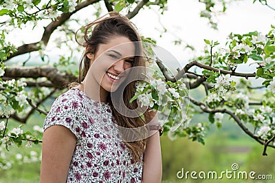 Young beautiful woman relaxing in the garden among blooming tree Stock Photo