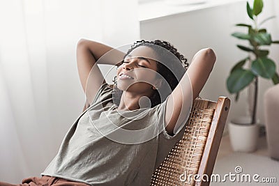 Young beautiful woman relaxing at home. Cute african american girl resting in her room Stock Photo