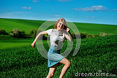 Young beautiful woman running on a green field Stock Photo