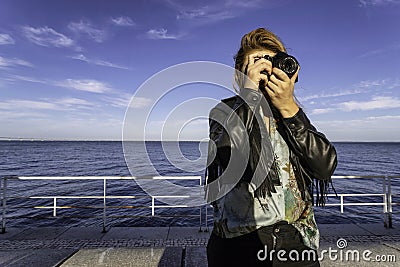 Young beautiful woman shooting with a professional analog film camera. Stock Photo