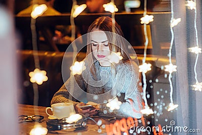 Young beautiful woman sitting in cafe, drinking coffee. Christmas, new year, Valentines day, winter holidays concept Stock Photo