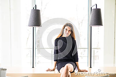 Young beautiful woman sitting on table in cafe Stock Photo