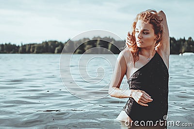 Young beautiful woman standing in the water. Stock Photo