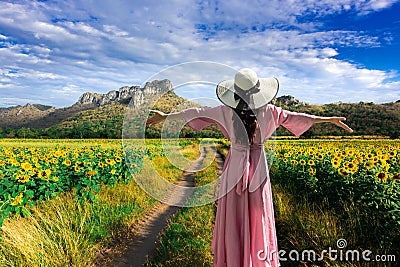 Young beautiful woman stands with her back turned on a blurred background with a field of sunflowers at Lopburi,Thailand Editorial Stock Photo