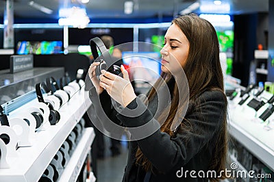 Beautiful woman testing headphones in modern store Stock Photo