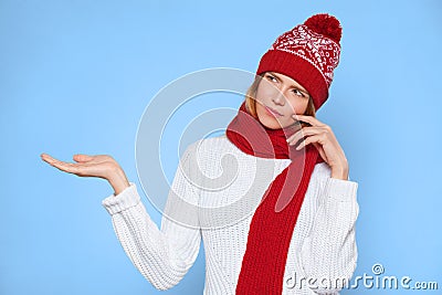Young beautiful woman thinking looking to the side with showing open hand palm at blank copy space, Christmas girl wearing hat and Stock Photo