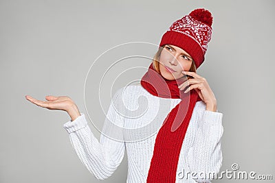 Young beautiful woman thinking looking to the side with showing open hand palm at blank copy space, Christmas girl wearing knitted Stock Photo