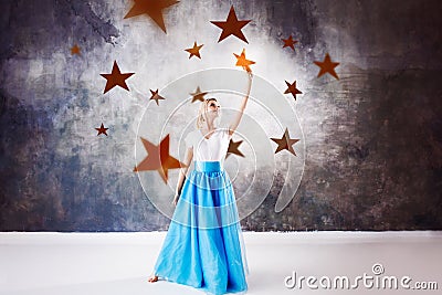 Young beautiful woman took a star from the sky. Fantasy concept, Reach for the dream Stock Photo