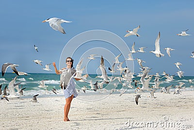 Young beautiful woman watching the seagulls flying Stock Photo