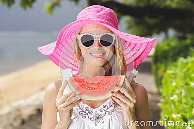 young beautiful woman with watermelon wearing pink sunhat and sunglasses Stock Photo