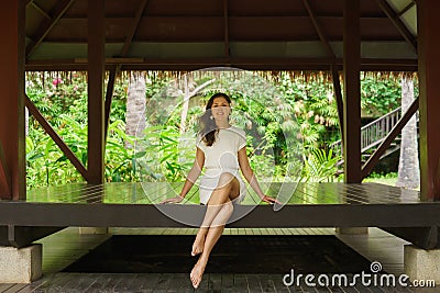 Young and beautiful woman in white dress. Woman posing in exotic Thai bungalow. Resting and traveling concept. Stock Photo