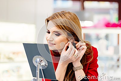 Young beauty elegance woman trying earrings in the jewelry store Stock Photo