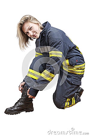 Young beauty firewoman in a protective suit tying shoelaces on boots and smiling Stock Photo