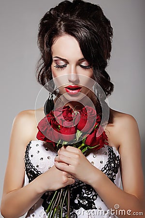 Young Beauty Smelling Bouquet of Red Roses. Pleasure & Harmony Stock Photo