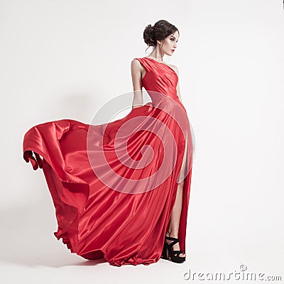 Young beauty woman in fluttering red dress. White background. Stock Photo