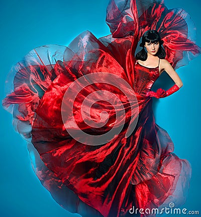 Young beauty woman in red waving flying dress. Dancer in silk dress. Stock Photo