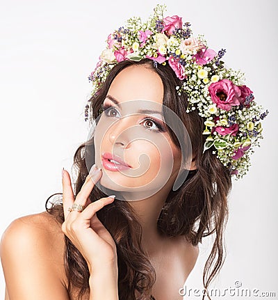 Young Beauty. Woman's Face with Bouquet of Natural Flowers Stock Photo