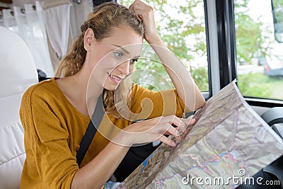 young bemused woman in campervan looking at map Stock Photo