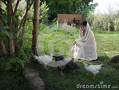 Girl feeding chickens in the garden Stock Photo