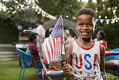 Young black boy holding flag at 4th July family garden party Stock Photo