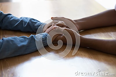 Young Black couple holding arms over table, having difficult conversation Stock Photo