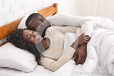 Young black couple waking up in bed in the morning Stock Photo