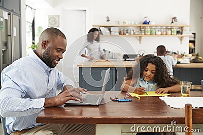 Young black family busy working in their kitchen Stock Photo