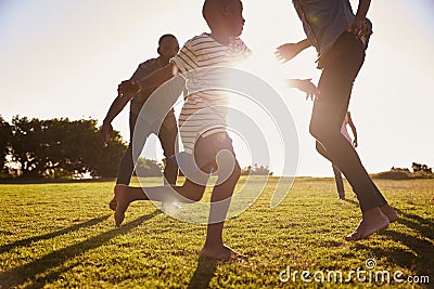 Young black family playing in a field in Summer Stock Photo