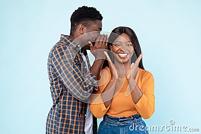 Black Man Sharing News With Excited Woman Whispering To Ear Stock Photo