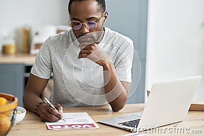 Young black man fulfilling document of mail voting Stock Photo