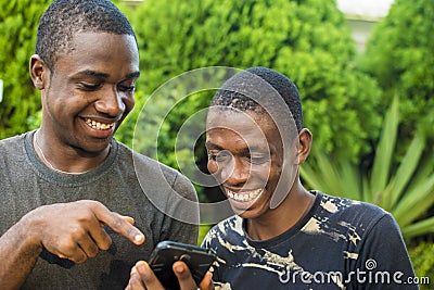 young black man showing a friend something interesting on his mobile phone Stock Photo