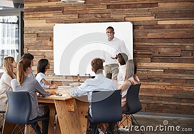 Young black man at whiteboard giving a business presentation Stock Photo