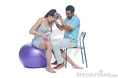 A young black man helps his white wife with birth pain with a ball. Partnered birth, partnered delivery. Isolated white Stock Photo