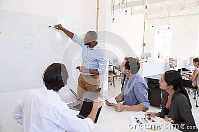 Young black man using a whiteboard in an office meeting Stock Photo