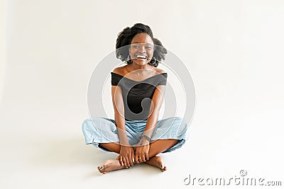 Young black woman with afro hairstyle smiling. Girl wearing black. Studio shot Stock Photo