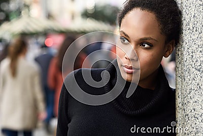 Young black woman with afro hairstyle standing in urban background Stock Photo
